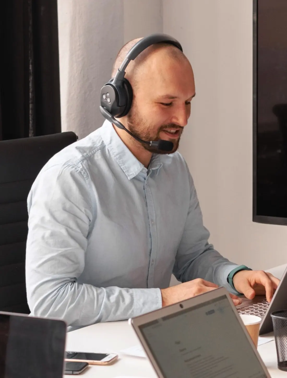 Atendente da DG Mídias, de headset, respondendo clientes pelo computador